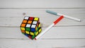 Magic Cube, Rubik`s Cube, and pencils on wooden table background. 3D combination puzzle. Royalty Free Stock Photo