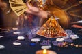 Magic divination and esotericism. Magic glass pyramid with a magical glow. In the background, a fortune teller holds a fan of Royalty Free Stock Photo