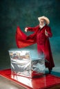 Modern stylish Santa Claus in red fashionable suit and cowboy`s hat on dark background Royalty Free Stock Photo