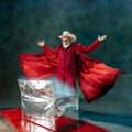 Modern stylish Santa Claus in red fashionable suit and cowboy`s hat on dark background Royalty Free Stock Photo