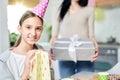 Magic gifts. Pretty teenaged latin girl smiling at camera while holding gift bag, receiving presents, celebrating