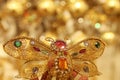 Magic gold butterfly with crystals on abstract shimmering gold b