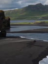 Magic iceland landscape with black lava sand and green eroded hills Royalty Free Stock Photo