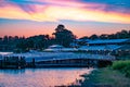 Magic Kingdom wharf and green forest on colorful sunset background at Walt Disney World area .