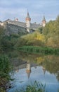 Magic medieval castle near pure lake and green park