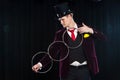 Magic, performance, circus, show concept - magician in top hat showing trick with linking rings