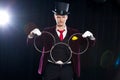 Magic, performance, circus, show concept - magician in top hat showing trick with linking rings