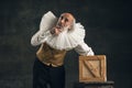 Elderly gray-haired man, actor or magician isolated on dark vintage background. Retro style, comparison of eras concept.