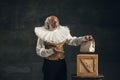 Elderly gray-haired man, actor or magician isolated on dark vintage background. Retro style, comparison of eras concept.