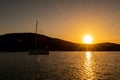 Magic, vibrant orange sunset over the hill and Sea with a dark sailing boat Royalty Free Stock Photo