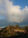 Fascinating blue sky with thunderclouds unloading and a rainbow over Findhorn Bay dunes, Scotland Royalty Free Stock Photo