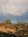 Fascinating blue sky with thunderclouds unloading and a rainbow over Findhorn Bay dunes, Scotland Royalty Free Stock Photo