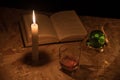 A magical ball, a scroll, a candle, a glass of cognac and old books in the dark of the night