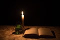 A magical ball, a scroll, a candle and an old book in the dark of the night Royalty Free Stock Photo