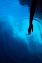 Magical blue color light in sea water and hand in dark