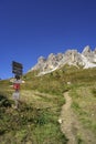 Magical Dolomite peaks of Pizes da Cir, Passo Gardena at blue sky and sunny day with a hiking trail direction signpost, South