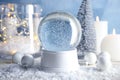 Magical empty snow globe with Christmas decorations and candles