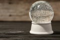 Magical empty snow globe on wooden table.