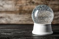 Magical empty snow globe on wooden table.