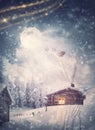 Magical holiday scene and Santa Claus sleigh with reindeers flying above the snowy house in the Christmas Eve. Wonderful