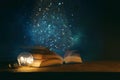 Magical image of open antique book over wooden table with glitter overlay Royalty Free Stock Photo