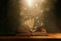Magical image of open antique book over wooden table with glitter overlay Royalty Free Stock Photo