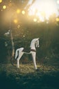 Magical image of vintage rocking horse in the forest at sunset Royalty Free Stock Photo