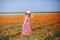 Beautiful young long red hair woman wearing in striped dress and straw hat standing on colorful flower tulip field in Holland Royalty Free Stock Photo