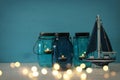 Magical mason jars whith candle light and wooden boat on the shelf Royalty Free Stock Photo