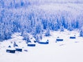 Magical mountain winter landscape, wooden houses and pine trees covered with snow Royalty Free Stock Photo