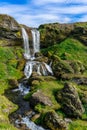 Magical natural view of a waterfall off the rocky cliff in Iceland