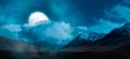 Magical Night Scene with Full Moon in cloudy sky. Mountain Landscape from Yukon