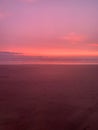 Magical pink sunset over the enchanted beach in a vertical view Royalty Free Stock Photo