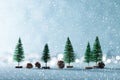 Magical snowy winter wonderland background. Miniature evergreen trees and pine cones on shiny blue background with bokeh. Royalty Free Stock Photo