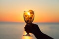 Magical spiritual sunrise sunset and glass of beautiful dandelion flowers in young female hand