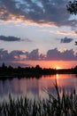 magical summer sunset and a pink sky over river. Clouds are reflected in calm water. Beautiful evening landscape. Royalty Free Stock Photo