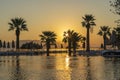 Magical sunrise with silhouette coconut palm tree and swimming pool in luxury hotel resort near sea. Beautiful morning seascape Royalty Free Stock Photo