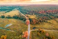 Aerial view of winding brook, country road, and fields