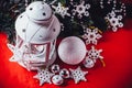 Magical white lantern is standing with white knit star on it and a fir tree branch and a snowball on a christmas red background. Royalty Free Stock Photo