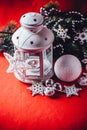 Magical white lantern is standing with white knit star on it and a fir tree branch and a snowball on a christmas red background. Royalty Free Stock Photo