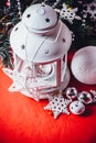 Magical white lantern is standing with white knit star on it and a fir tree branch and a snowball on a christmas red background. Royalty Free Stock Photo