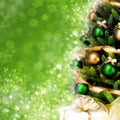 Magically decorated Christmas Tree with balls, ribbons and golden garlands on a blurred green shiny background