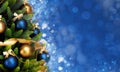 Magically decorated Fir Tree with balls, ribbons and garlands on a blurred Christmas blue shiny and sparkling background.