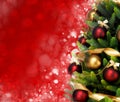 Magically decorated Fir Tree with balls, ribbons and garlands on a blurred Christmas-red shiny and sparkling background.