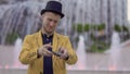 Magician in hat and yellow jacket skillfully moving playing cards in hands