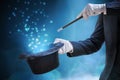 Magician or illusionist is showing magic trick. Blue stage light in background Royalty Free Stock Photo
