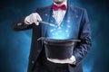 Magician or illusionist is showing magic trick. Blue stage light in background Royalty Free Stock Photo