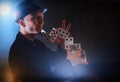 Magician showing trick with playing cards. Magic or dexterity, circus, gambling. Prestidigitator in dark room with fog Royalty Free Stock Photo