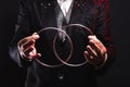 Magician shows trick with metal rings. Manipulation with props.