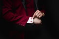 Magician shows trick with playing cards, disappearance in sleeve